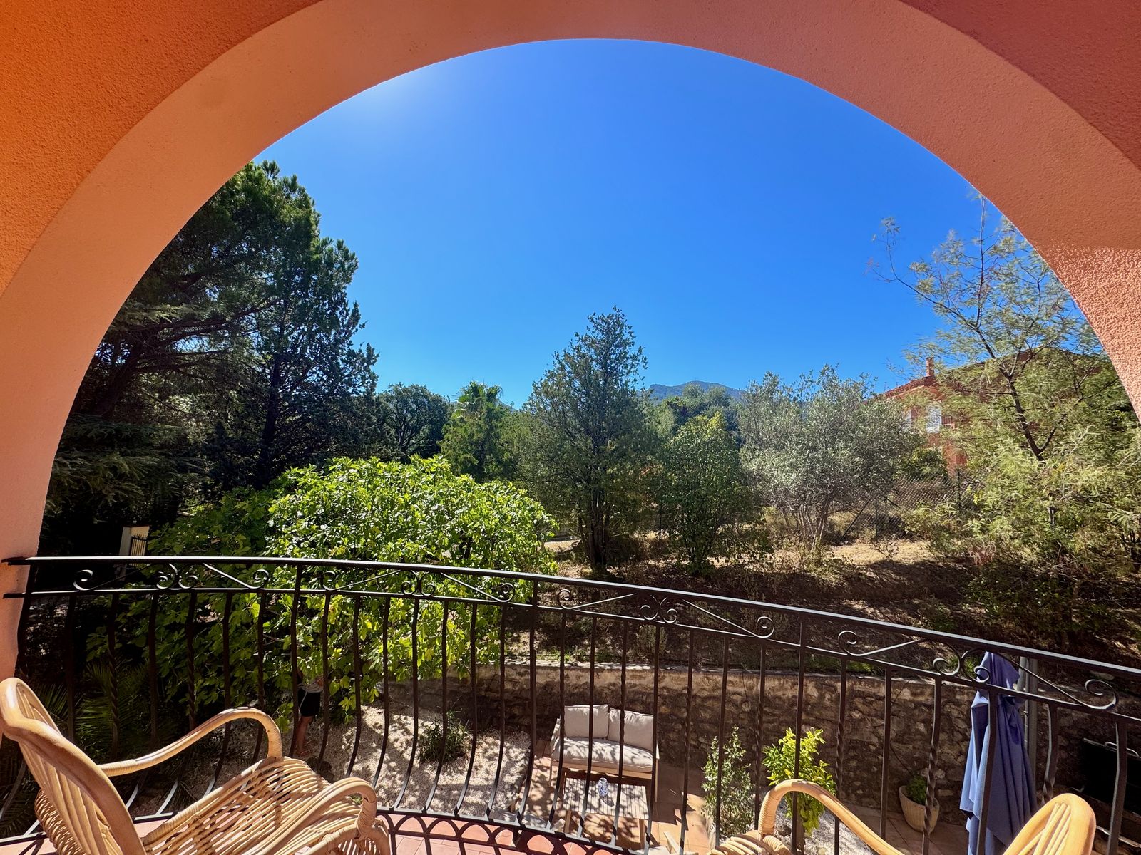 L'arche du balcon encadre le jardin et le ciel