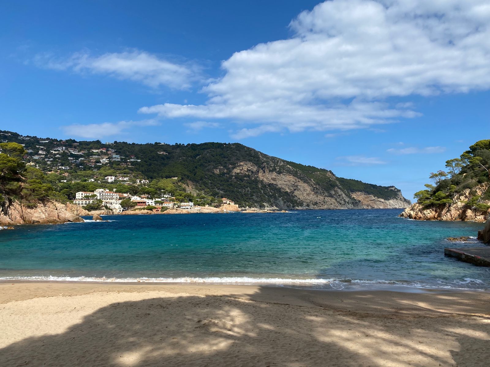La plage d'Aiguablava, sable clair, eau turquoise et pinède au-dessus des rochers